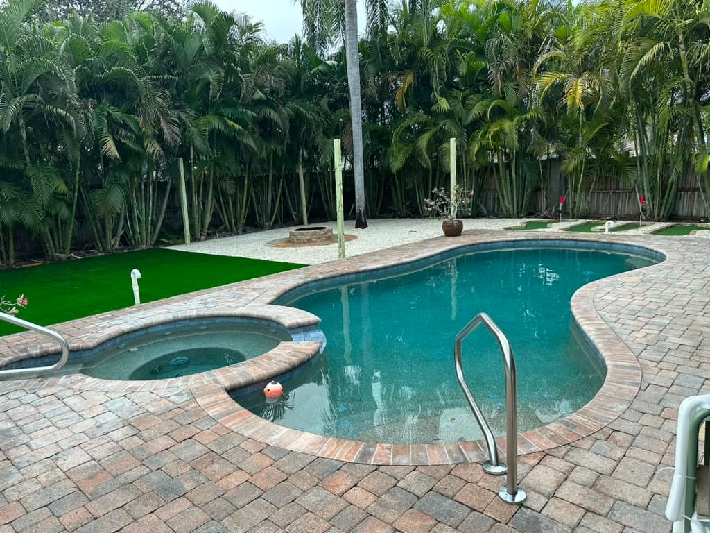 Paver pool deck with spa and palms