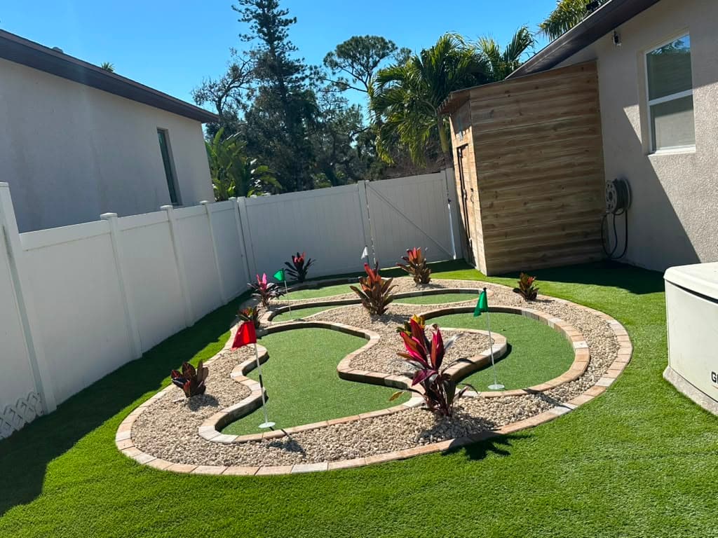Artificial-turf backyard with landscaping at a Palm Harbor home